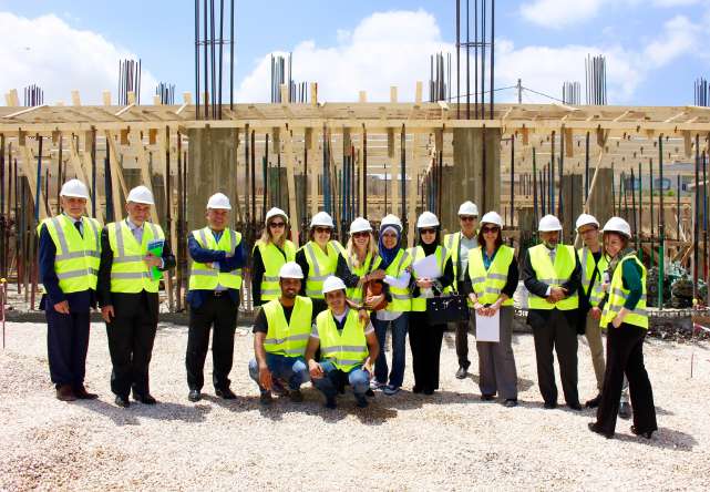 Project team in safety vests and hard hats during a construction site visit